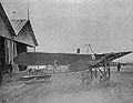 On the Aerodrome. Airplane with a Pilot near Hangars